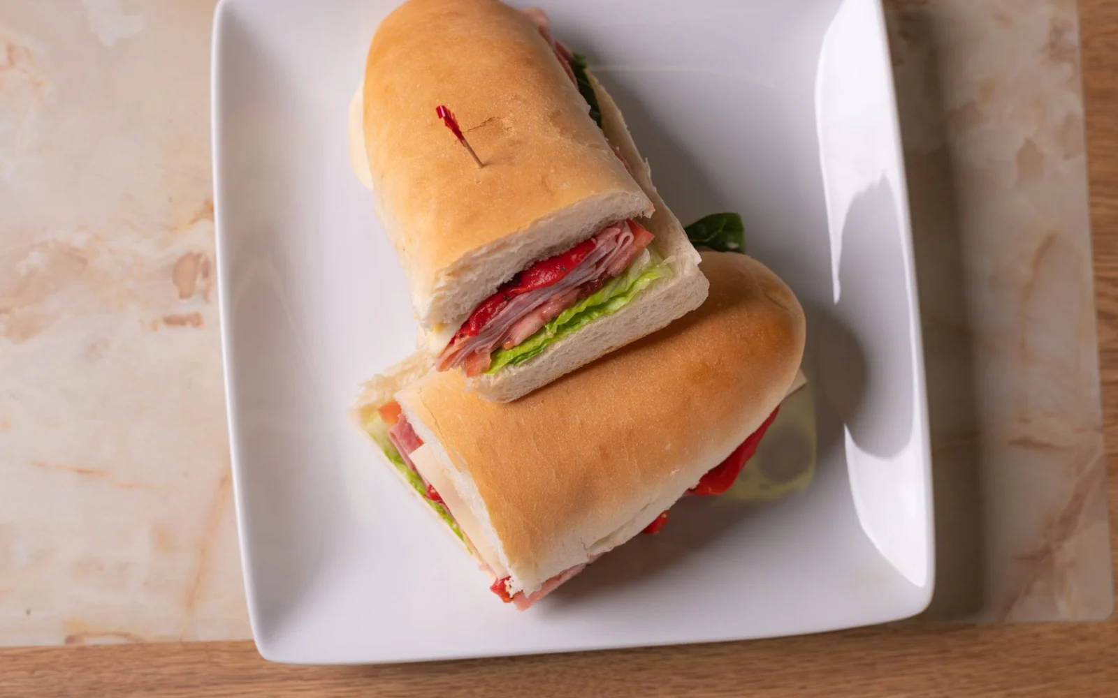 Italian sub cut in half on a white plate