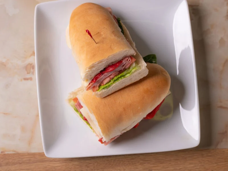 Italian sub cut in half on a white plate