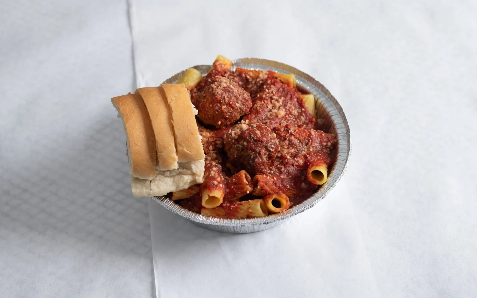Pasta with homemade sauce, meatballs and fresh bread